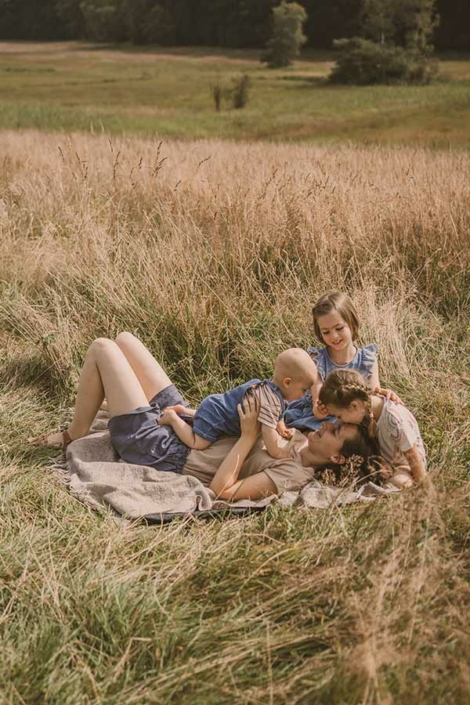 Mutter tobt mit ihren Kindern auf der Wiese