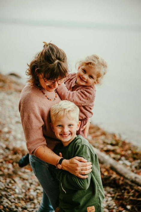 Mutter nimmt ihre zwei Kinder in den Arm