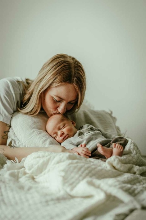 Mama küsst ihr Baby auf den Kopf